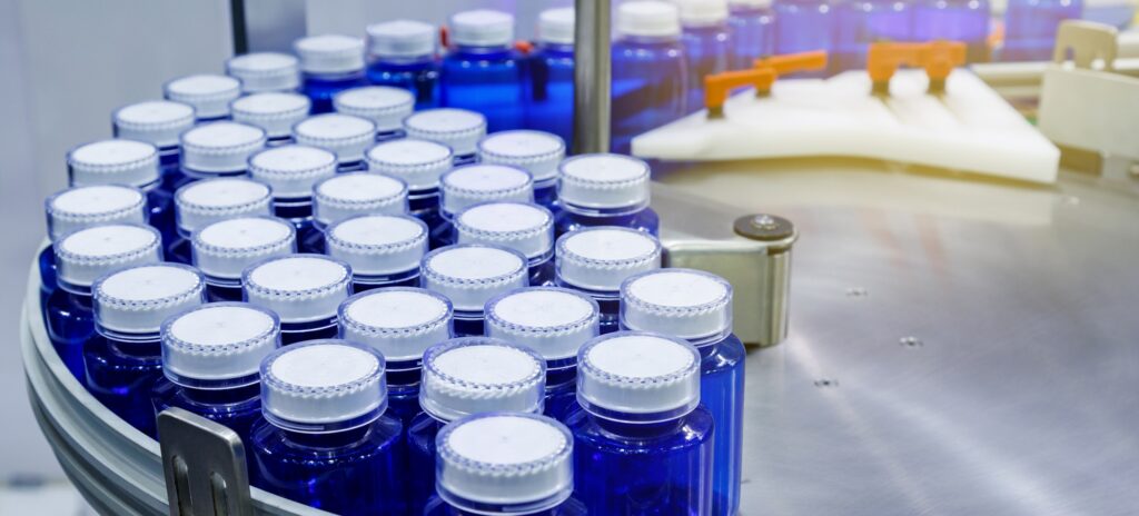 plastic bottle on conveyor belt at filling machine in medical factory. pharmaceutical manufacturing.