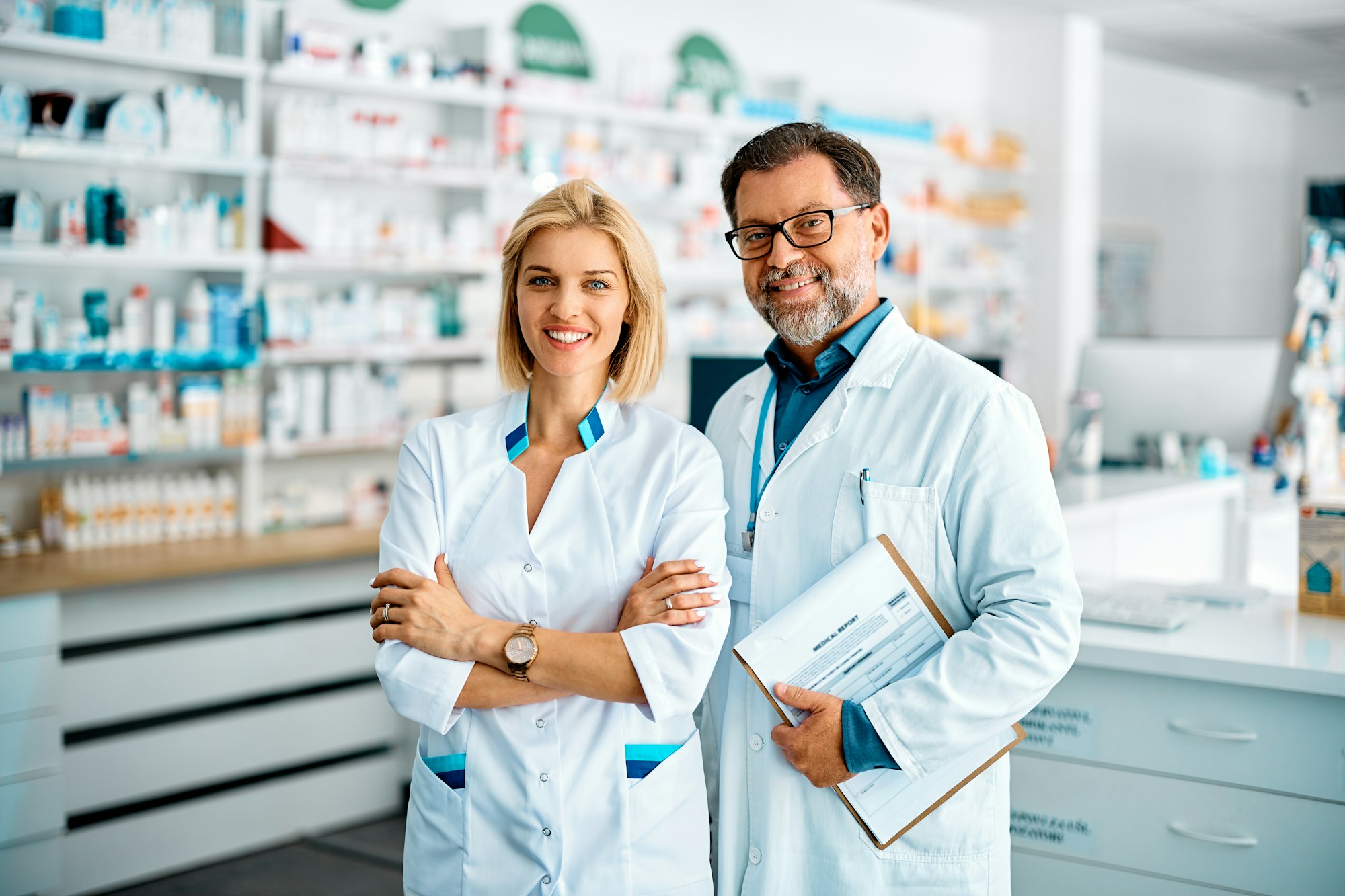 Portrait of happy pharmacists in drugstore looking at camera.