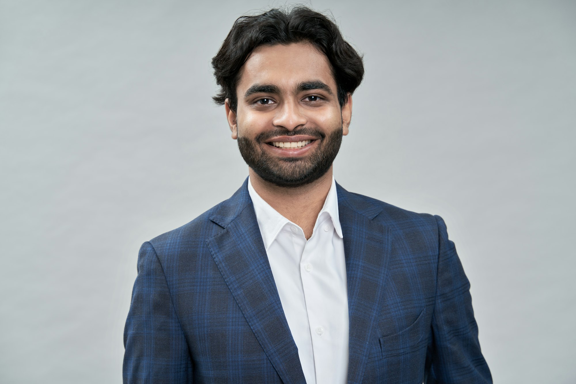 Happy young indian arab business man wearing suit. Headshot portrait